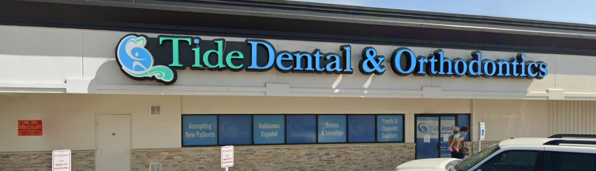 Tide Dental & Orthodontics storefront exterior with illuminated signage and entrance doors.